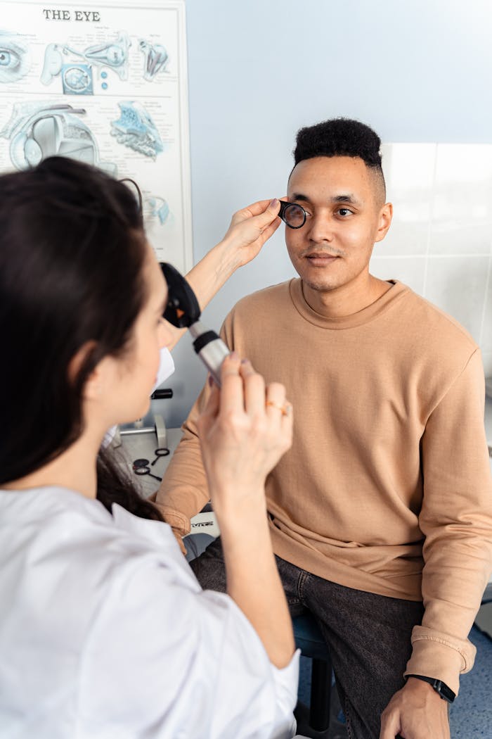 Optometrist conducting eye examination on patient in clinic setting.